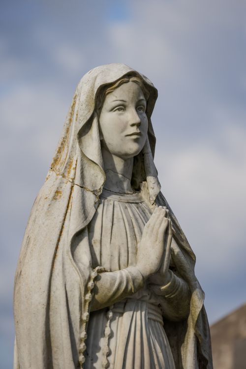 Free A serene statue of a praying figure in an old cemetery, symbolizing peace and remembrance. Stock Photo