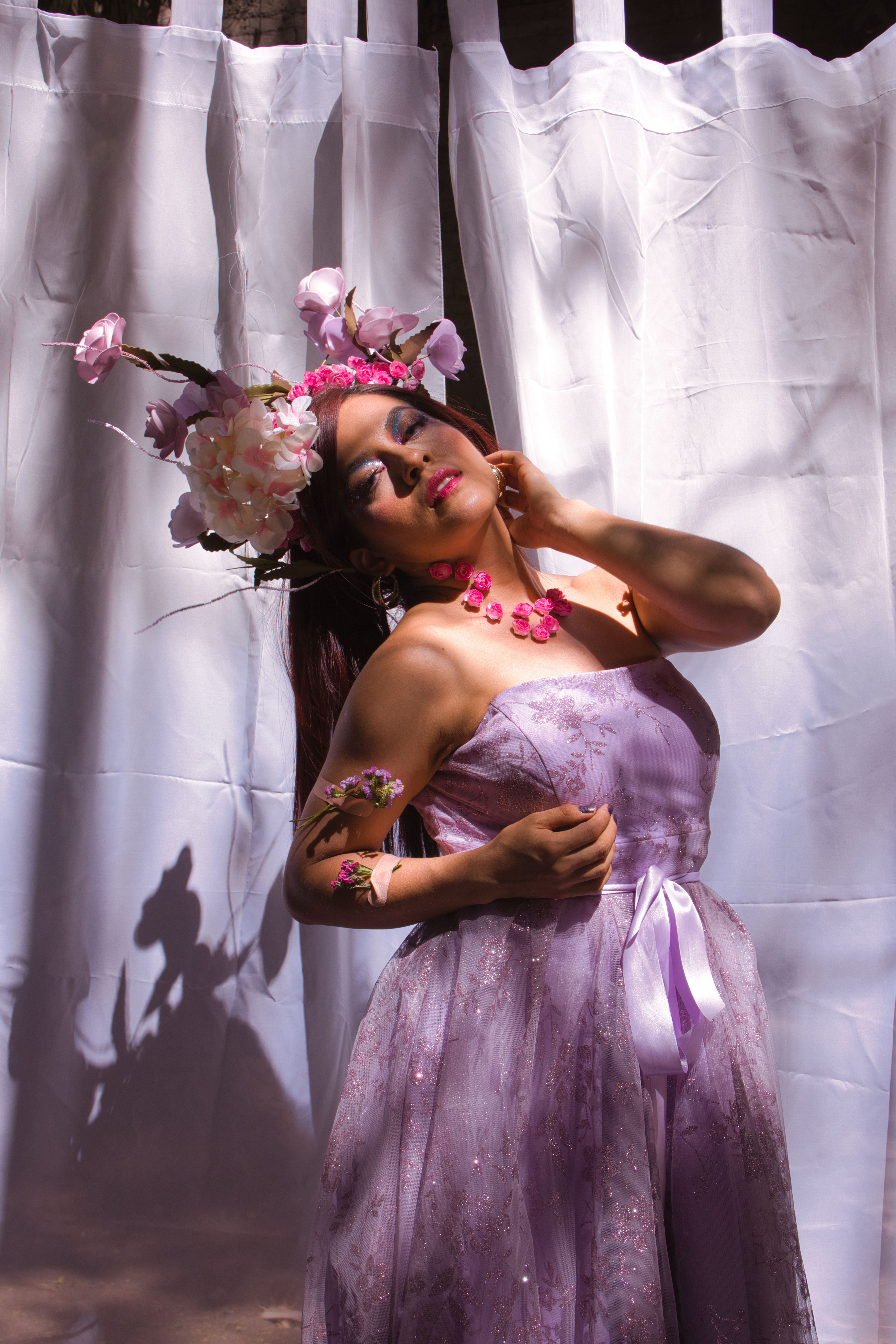 Fotomural Una mujer con un vestido lila y un tocado floral posa con gracia en un interior.