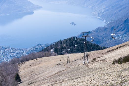 Scenic landscape featuring Lake Maggiore view with ski lift on a sunny day.