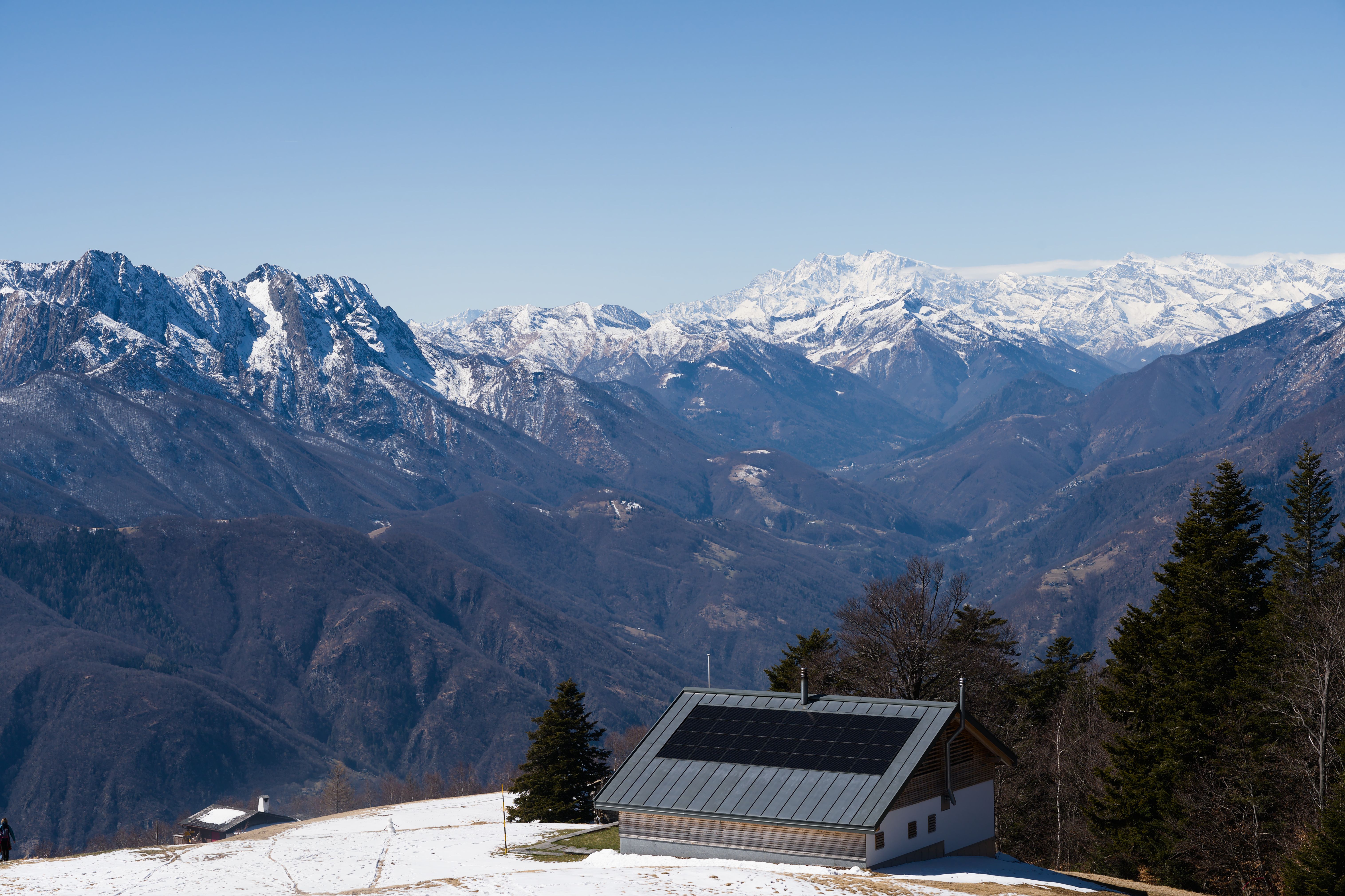 Minimalist ultra-luxury mountain villa with floor-to-ceiling windows overlooking a misty valley at dawn.