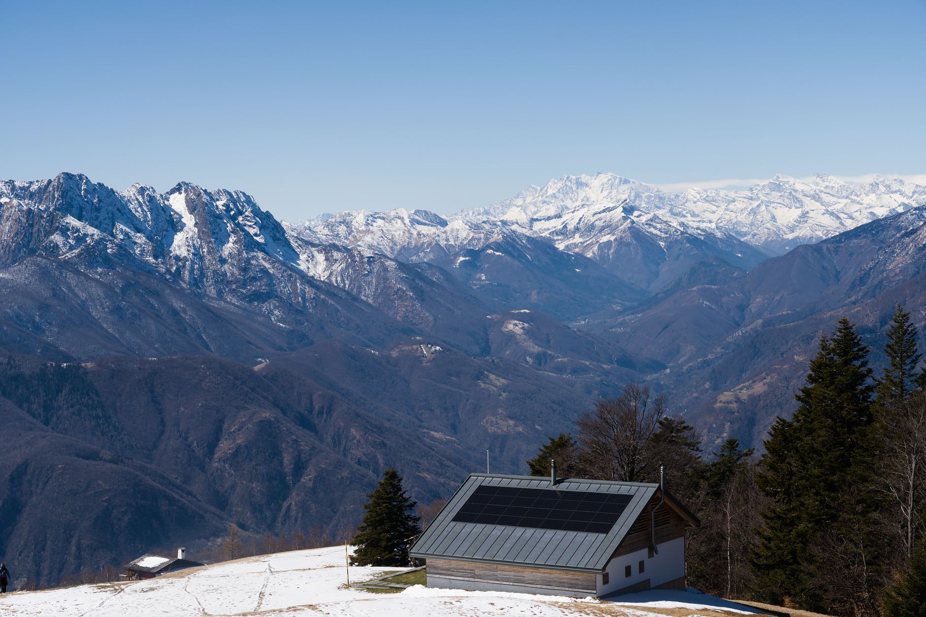 Minimalist ultra-luxury mountain villa with floor-to-ceiling windows overlooking a misty valley at dawn.