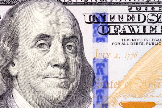 Detailed close-up of Benjamin Franklin's portrait on a 100 dollar bill showing July 4, 1776.