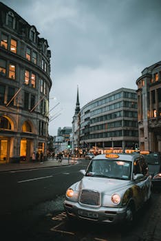黄昏时分，在经典的伦敦街道上，一辆标志性的黑色出租车穿行于历史悠久的建筑之间