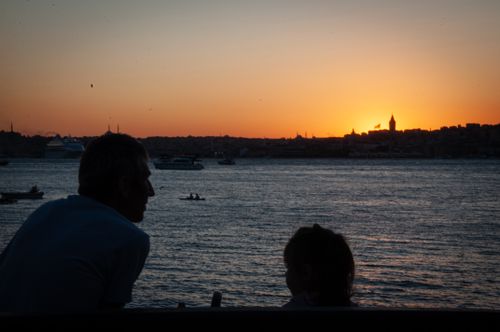 Free Silhouettes of people at sunset with Istanbul skyline in the background, capturing the Bosphorus' serene beauty. Stock Photo