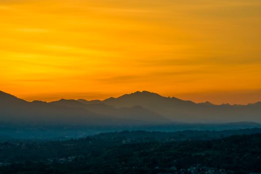 Stunning view of the Italian mountain range silhouetted against a vibrant orange sunset sky.
