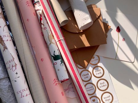 Assortment of gift wrapping paper rolls and envelopes with holiday designs, ready for festive occasions.