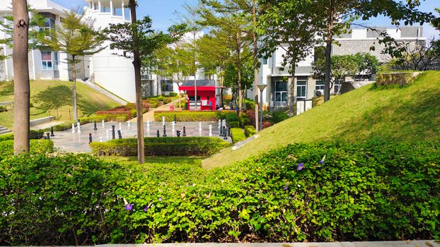 View of a modern park with outdoor chess set and lush greenery, perfect for relaxation.