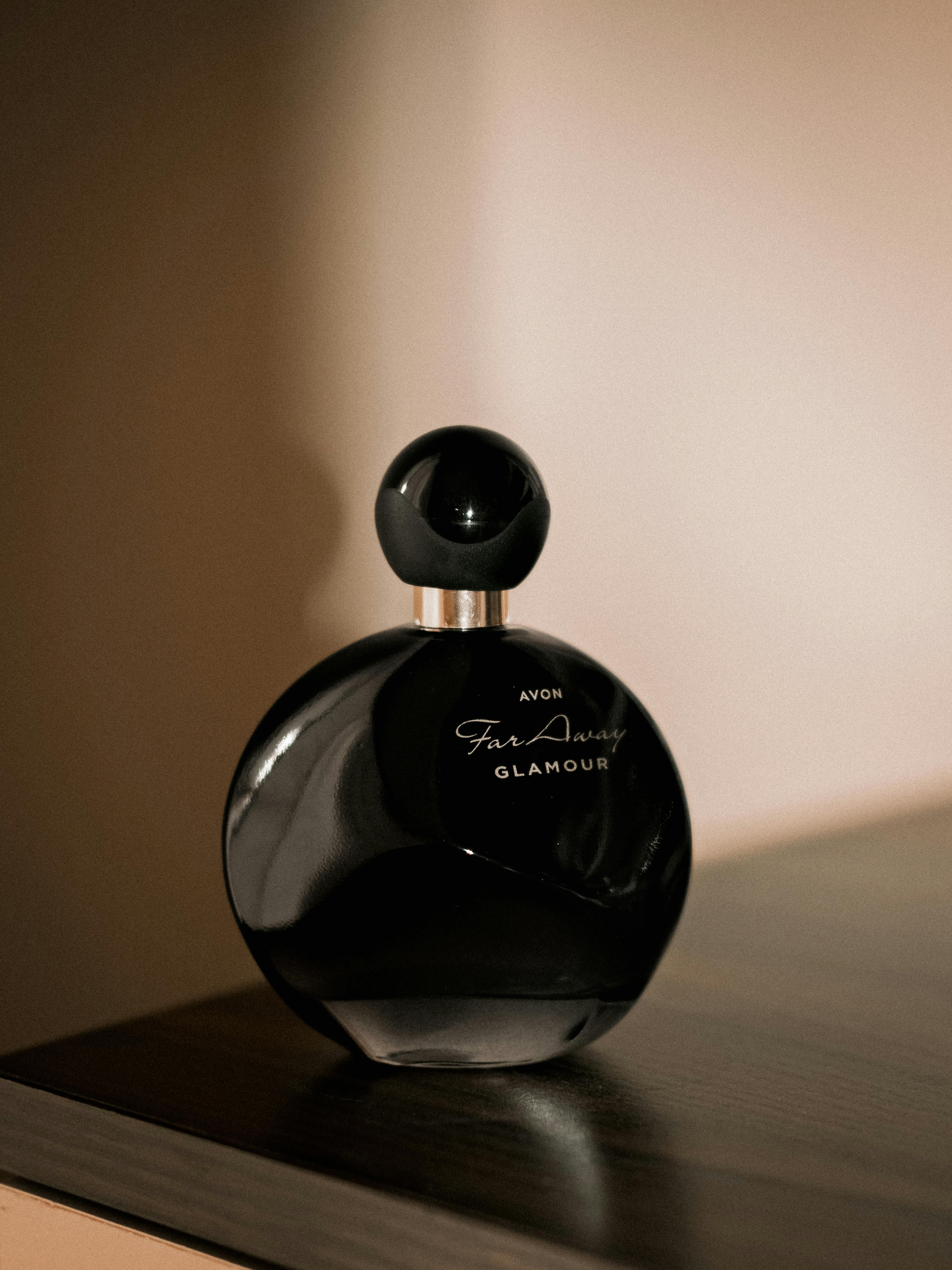 Kostenlos Stilvoller schwarzer Parfümflakon auf einer Holzoberfläche, der Luxus und Eleganz ausstrahlt. Stock-Foto