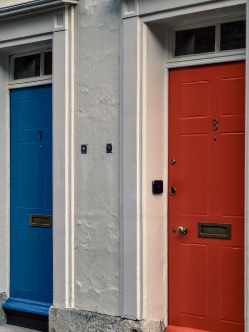 Bright blue and red doors side by side in Oxford, England. Vivid urban contrast.