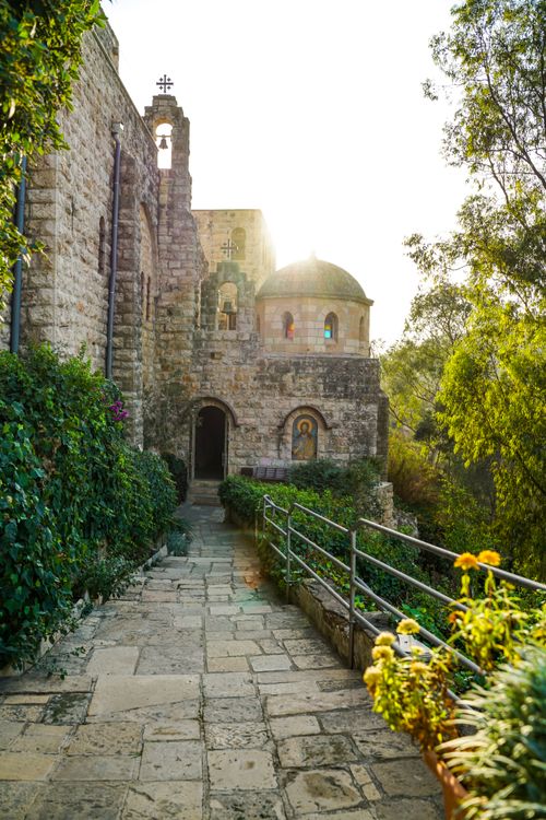 Free A peaceful walkway leading to a historic monastery bathed in sunlight. Stock Photo