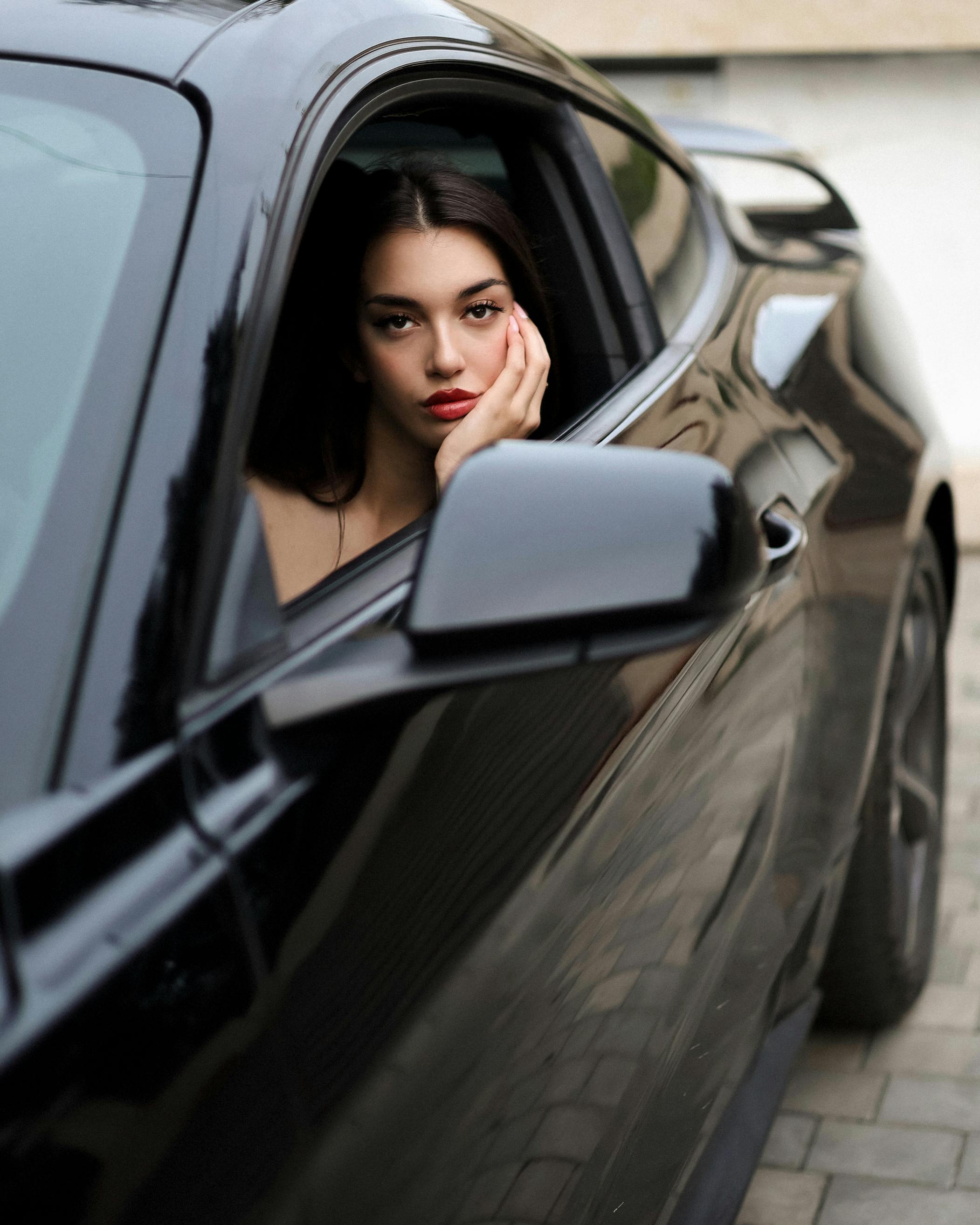 Gratis Retrato de una mujer elegante en un automóvil negro por la noche en Tbilisi, Georgia, mostrando la moda moderna y el estilo de vida urbano. Foto de stock