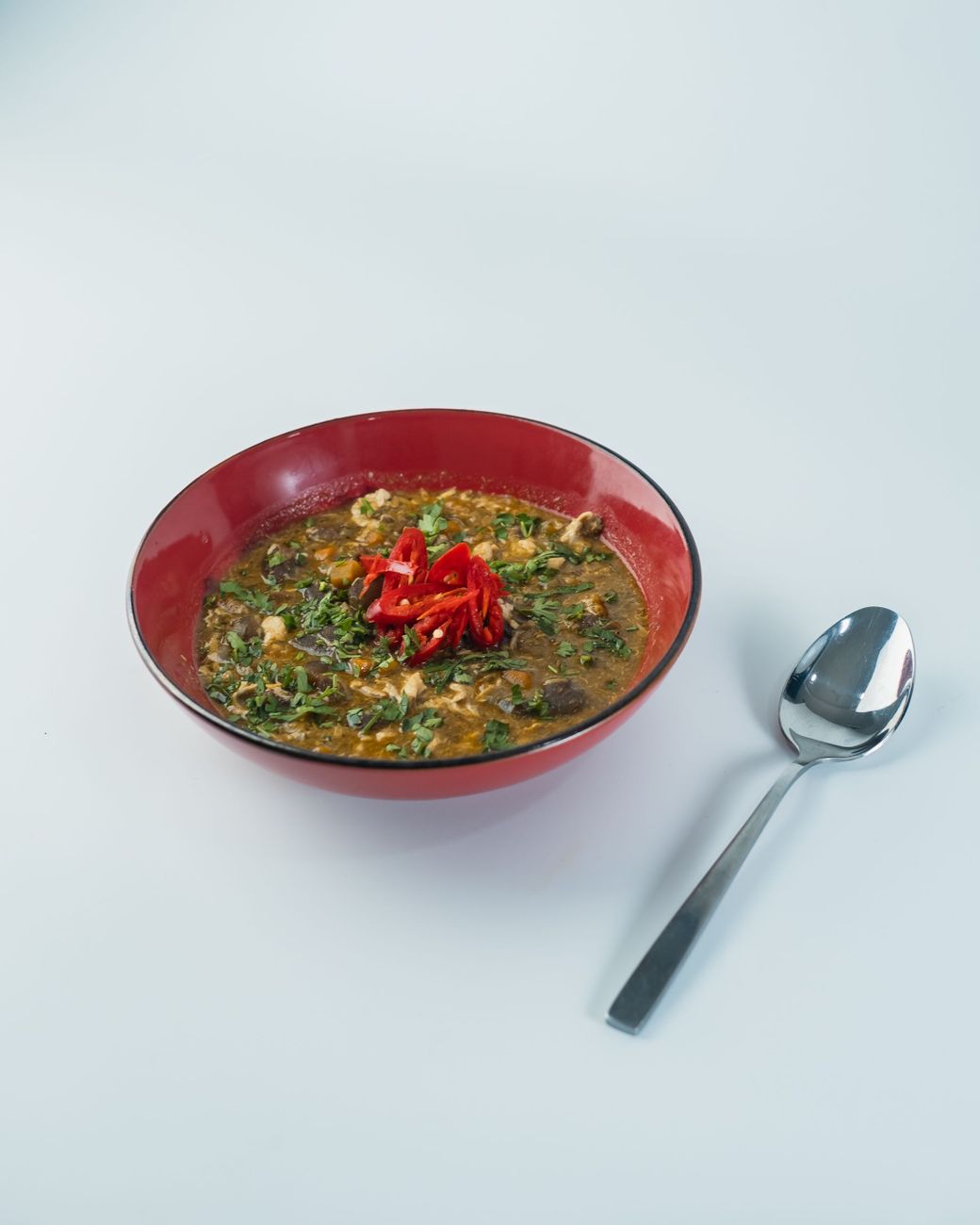 Bowl of Nigerian catfish pepper soup with visible scotch bonnet peppers and aromatic spices