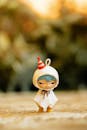 Cute Figurine in Party Hat on Warm Background