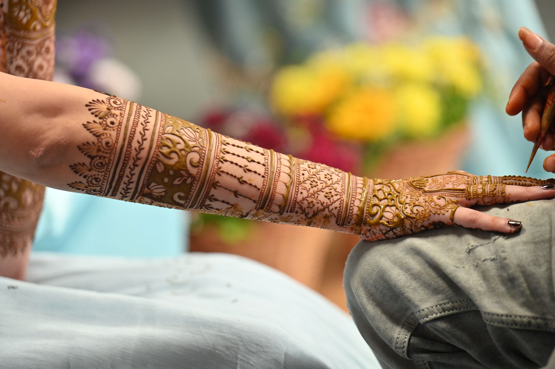Close-up of hands applying a temporary tattoo to clean skin for realistic finish