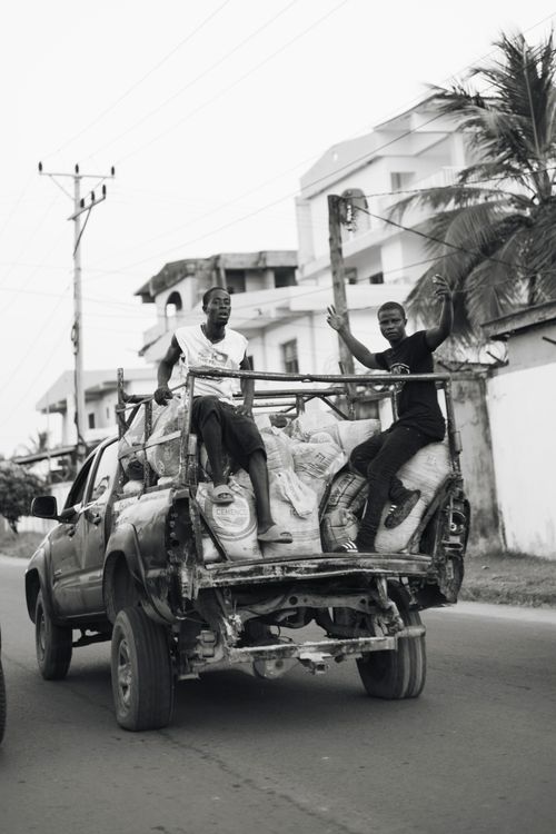 Free Black and white photo of two men on a truck in Monrovia, Liberia. Stock Photo