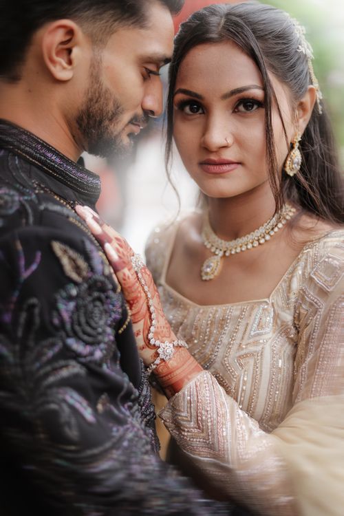 Free Close-up portrait of a couple in traditional Indian wedding attire with henna design. Stock Photo