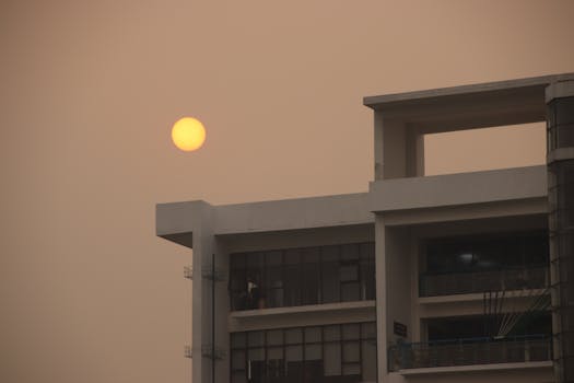Urban sunset view with a modern building against a warm sky.