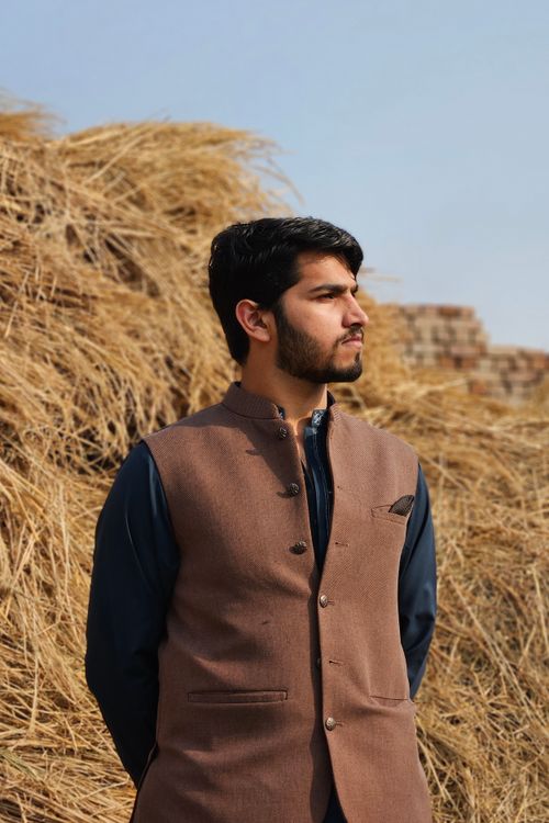 Free A fashionable man in traditional shalwar kameez stands confidently outdoors. Stock Photo