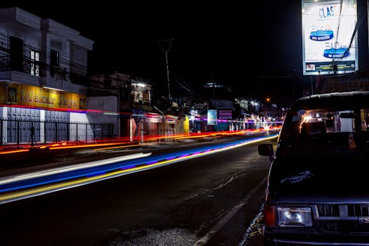 Long exposure of a bustling street in Jawa Barat at night, capturing vibrant light trails.