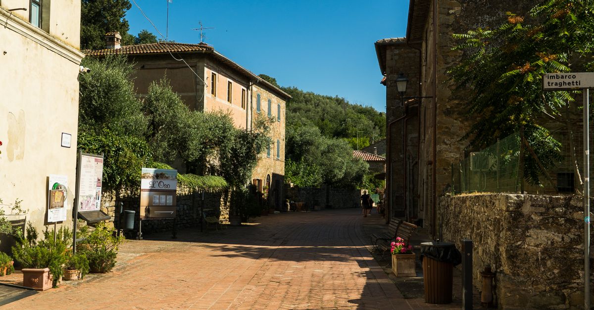 Denzel Washington walking through a sunlit Italian town with a serious expression