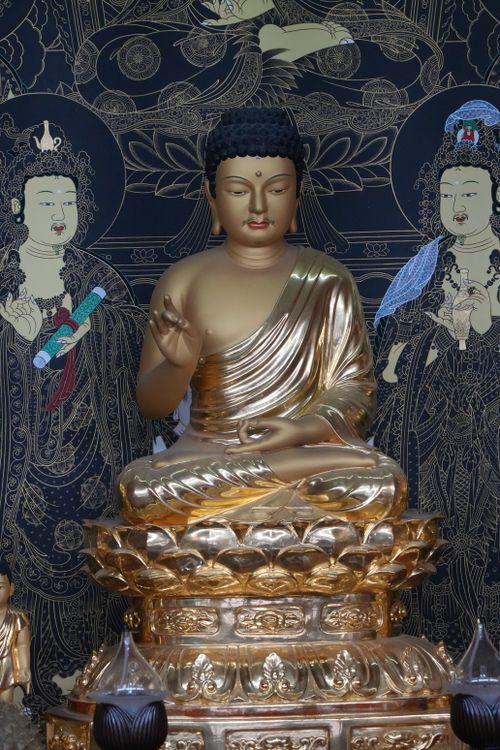 Free A beautiful golden Buddha statue surrounded by intricate art in a temple in Busan, South Korea. Stock Photo