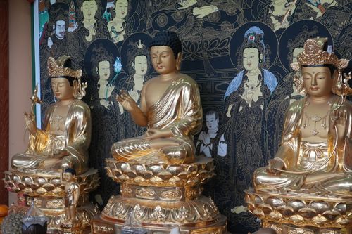 Free Elegant golden Buddha statues surrounded by intricate artwork at a Busan temple. Stock Photo