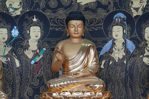 Free A serene golden Buddha statue surrounded by intricate art in a Busan temple. Stock Photo
