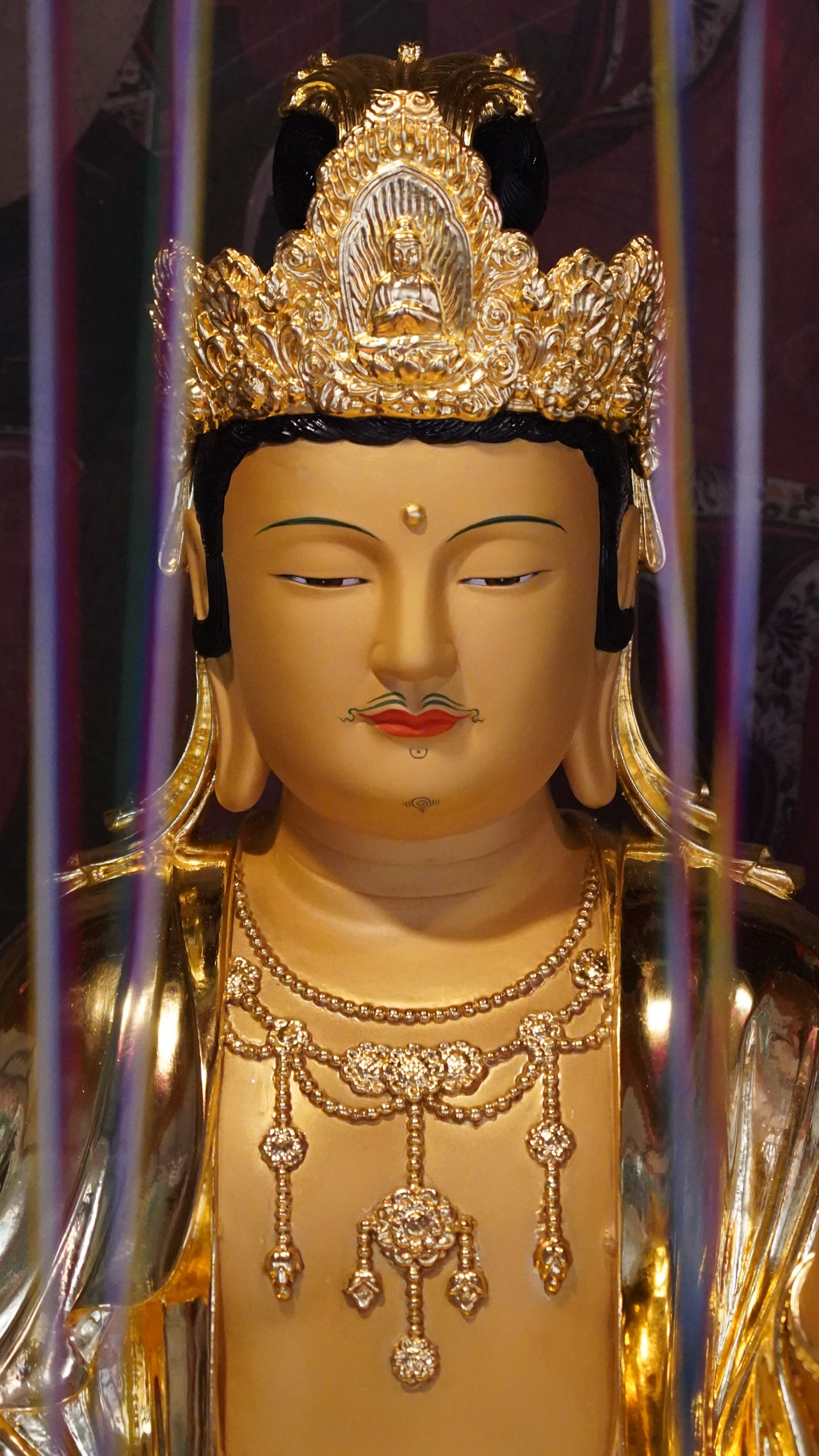 Detailed view of a golden Avalokiteshvara statue with intricate carvings, located in South Korea.