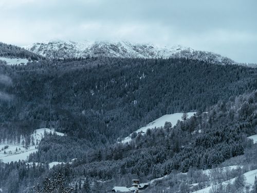 Free A peaceful snowy mountain landscape in Murau, Austria, showing dense forests and distant peaks. Stock Photo