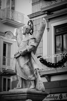 Black and white photo of a historic statue in a charming Italian village square.