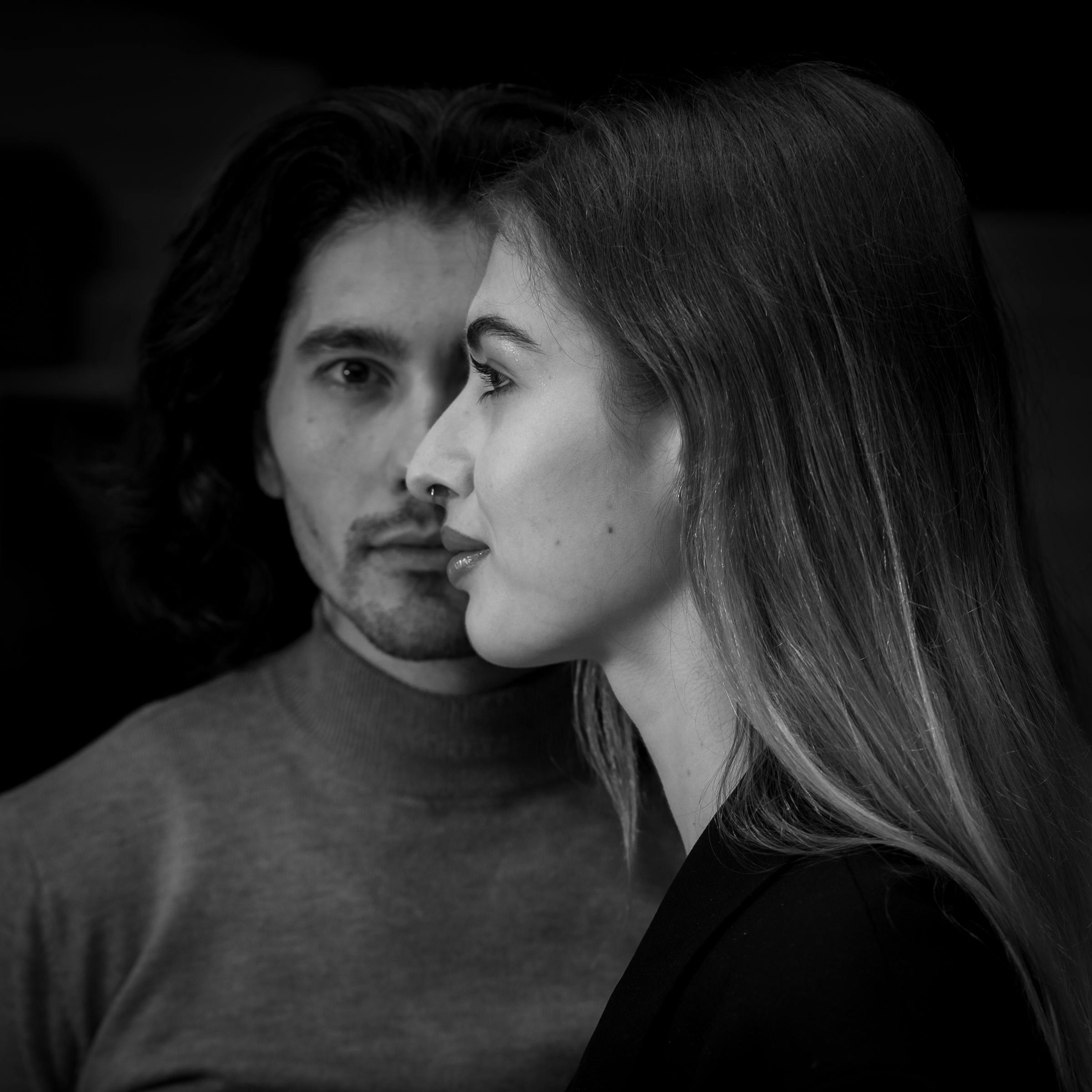 Artistic black and white portrait featuring two thoughtful individuals.