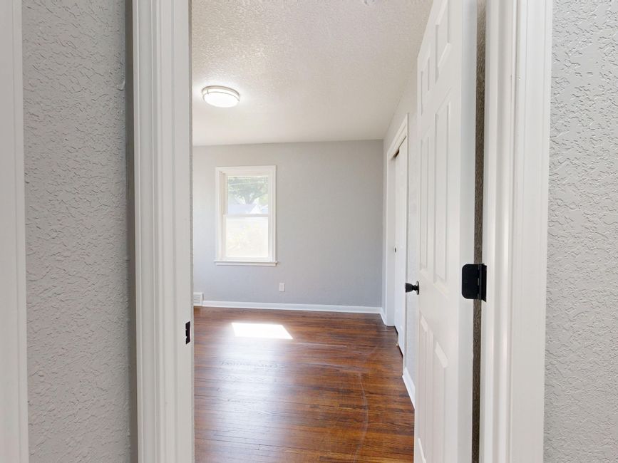 Interior view of an empty room with wooden floors and natural light.
