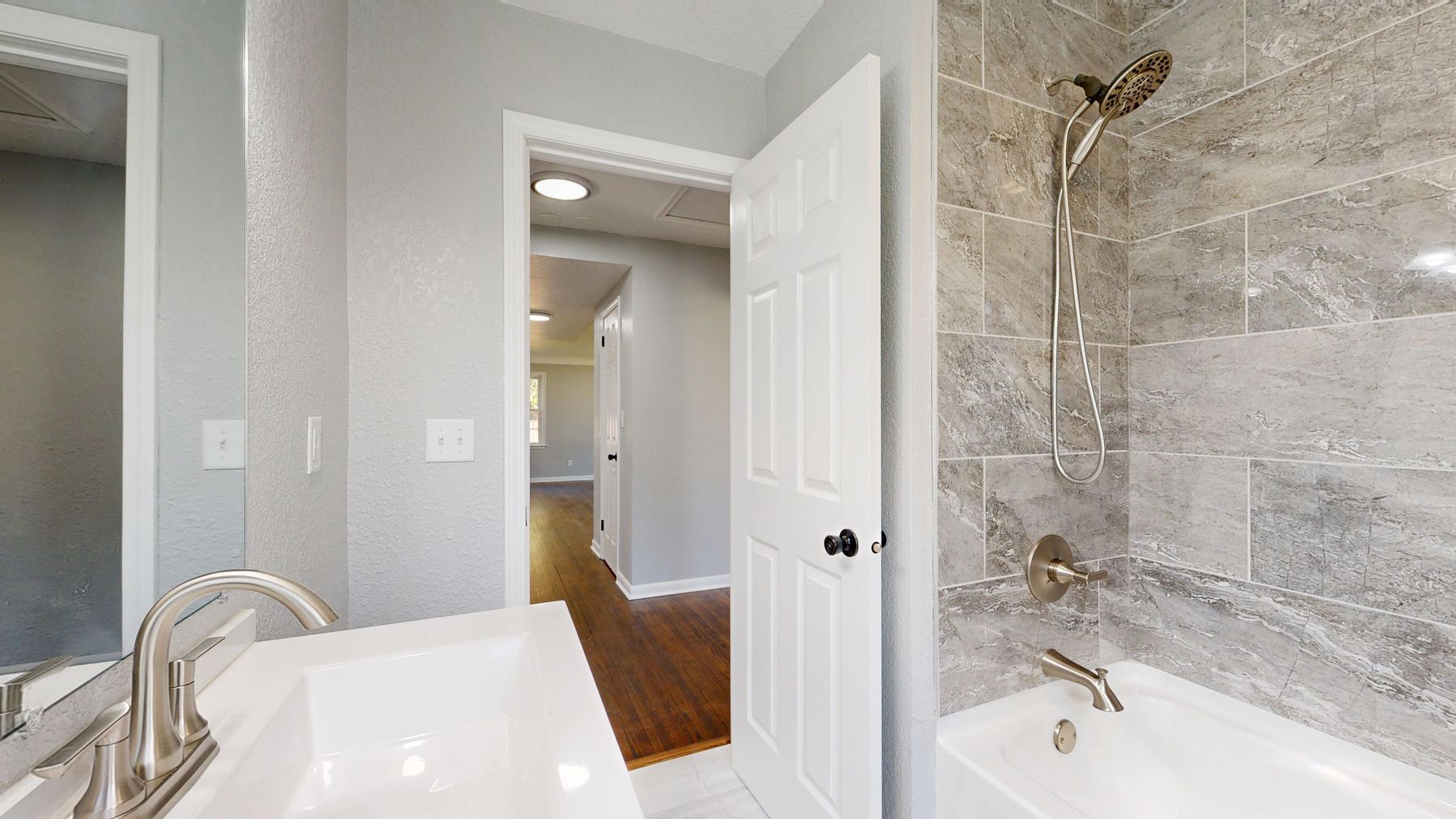 Modern bathroom with grey tile, neutral finishes and bright natural light