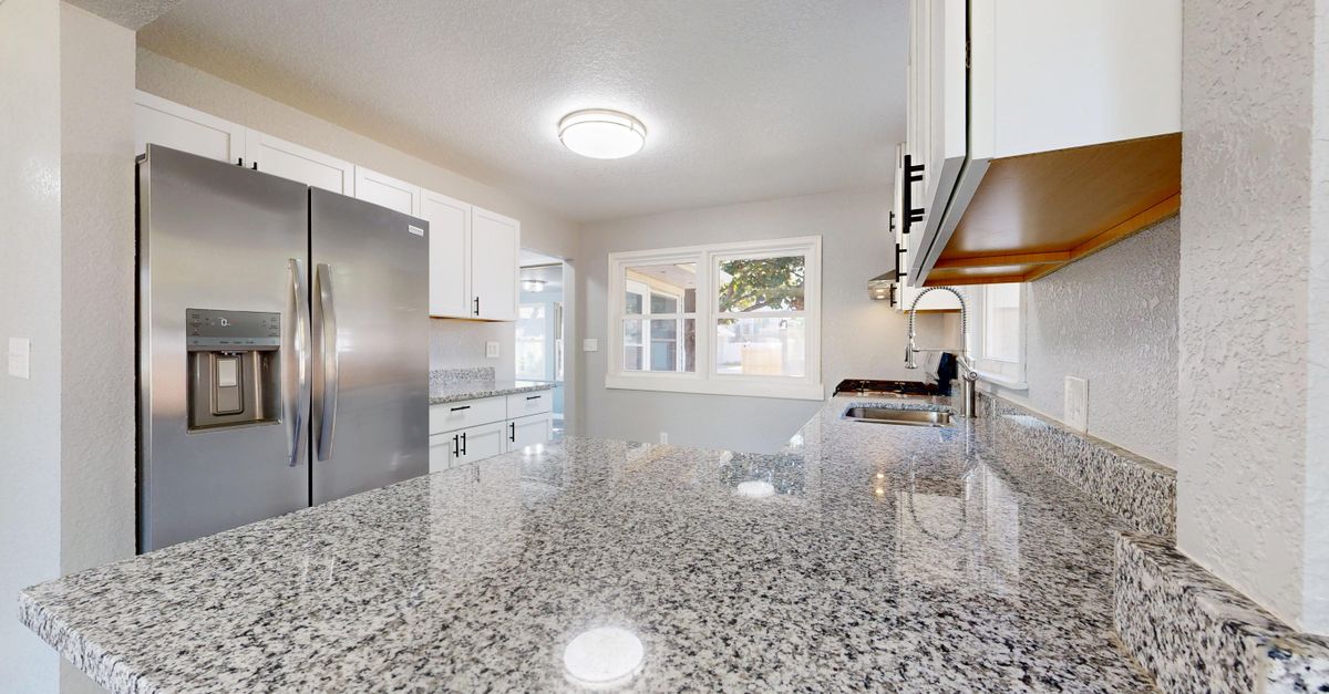 Spacious kitchen featuring granite countertops and stainless steel appliances.