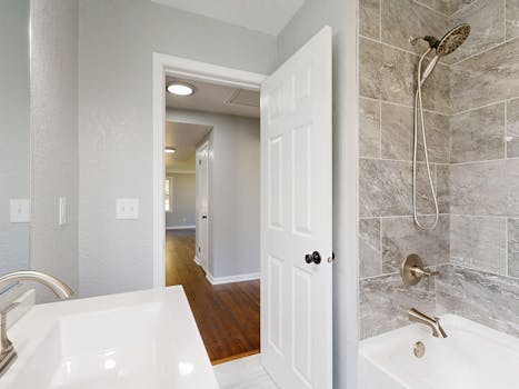 Contemporary bathroom featuring a grey tile shower and sleek fixtures.