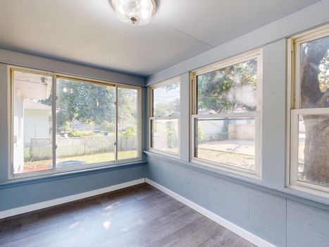Spacious sunroom with large windows overlooking a garden. Perfect for relaxation.