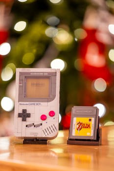 Classic Game Boy and Zelda game cartridge with blurred festive bokeh in the background.