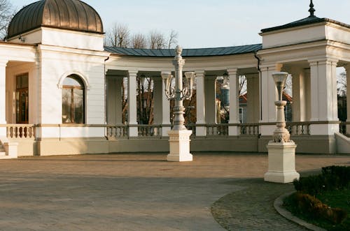 High columns of white concrete historic building located in park in sunny day