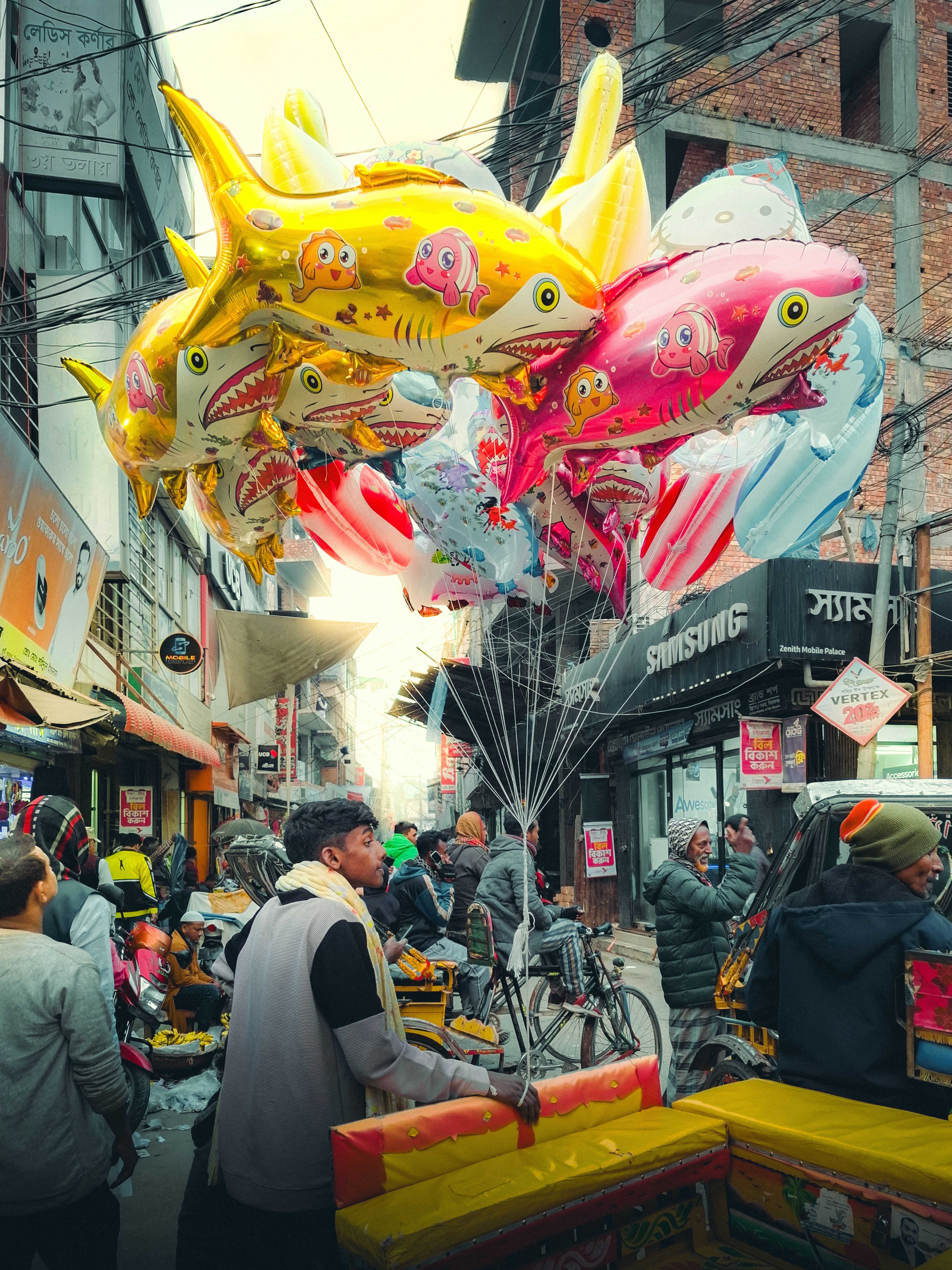 Colorful Balloon Vendor in Busy Ullapara Street · Free Stock Photo