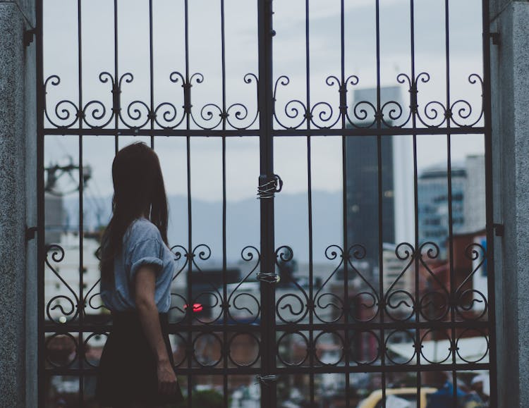 Woman Standing Beside Gate