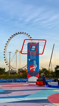 Vibrant basketball court with Ferris wheel backdrop in São Paulo, capturing a lively outdoor sports scene.