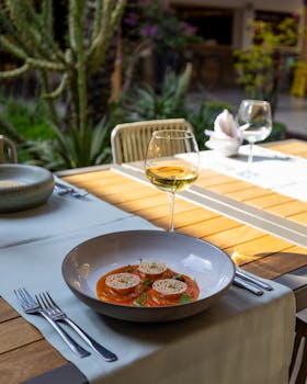Gourmet ravioli served in an elegant outdoor setting with a glass of wine, perfect for fine dining experiences.