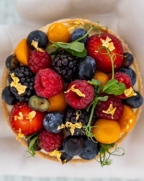 Free A vibrant fruit tart adorned with berries and edible gold, captured in Bodrum, Türkiye. Stock Photo