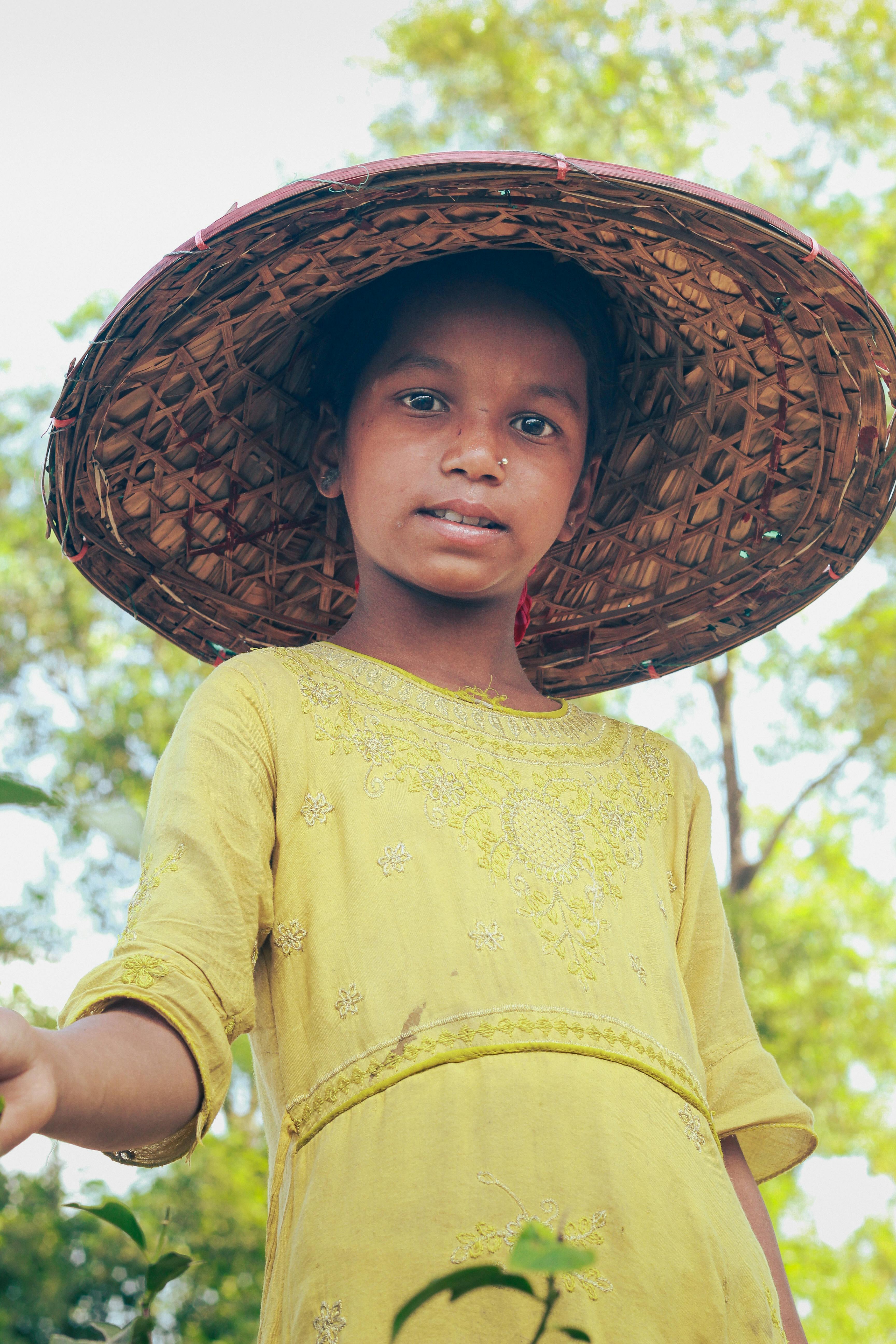 De franc Una noia amb un barret tradicional posa en un assolellat jardí de te a Sreemangal, Bangladesh. Foto d'estoc