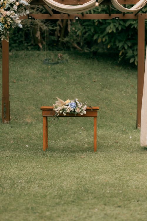 Free A wooden table with wedding floral decor in an outdoor garden setting. Stock Photo