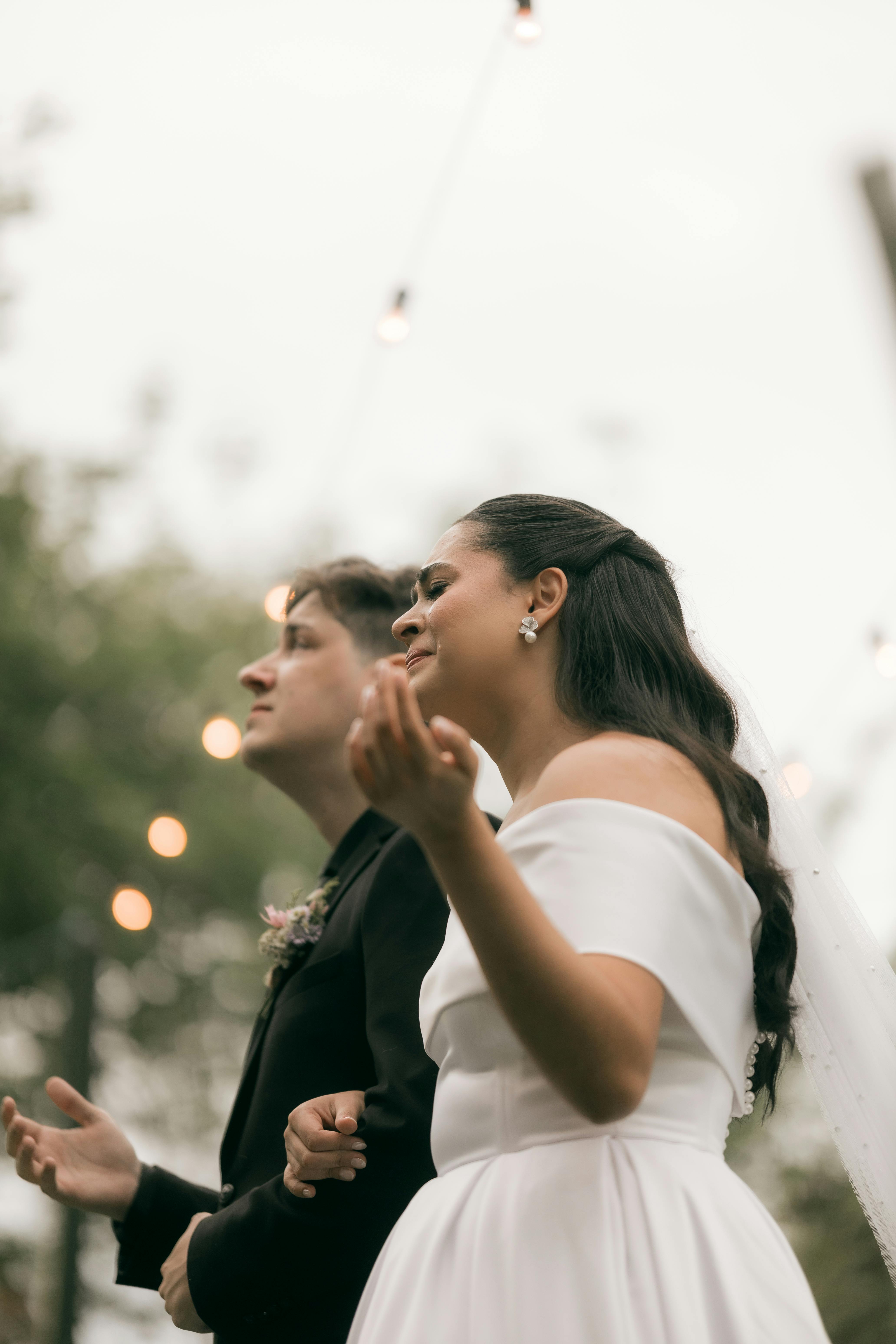 Gratis Novia y novio al aire libre durante una ceremonia de boda con luces de noche. Foto de stock
