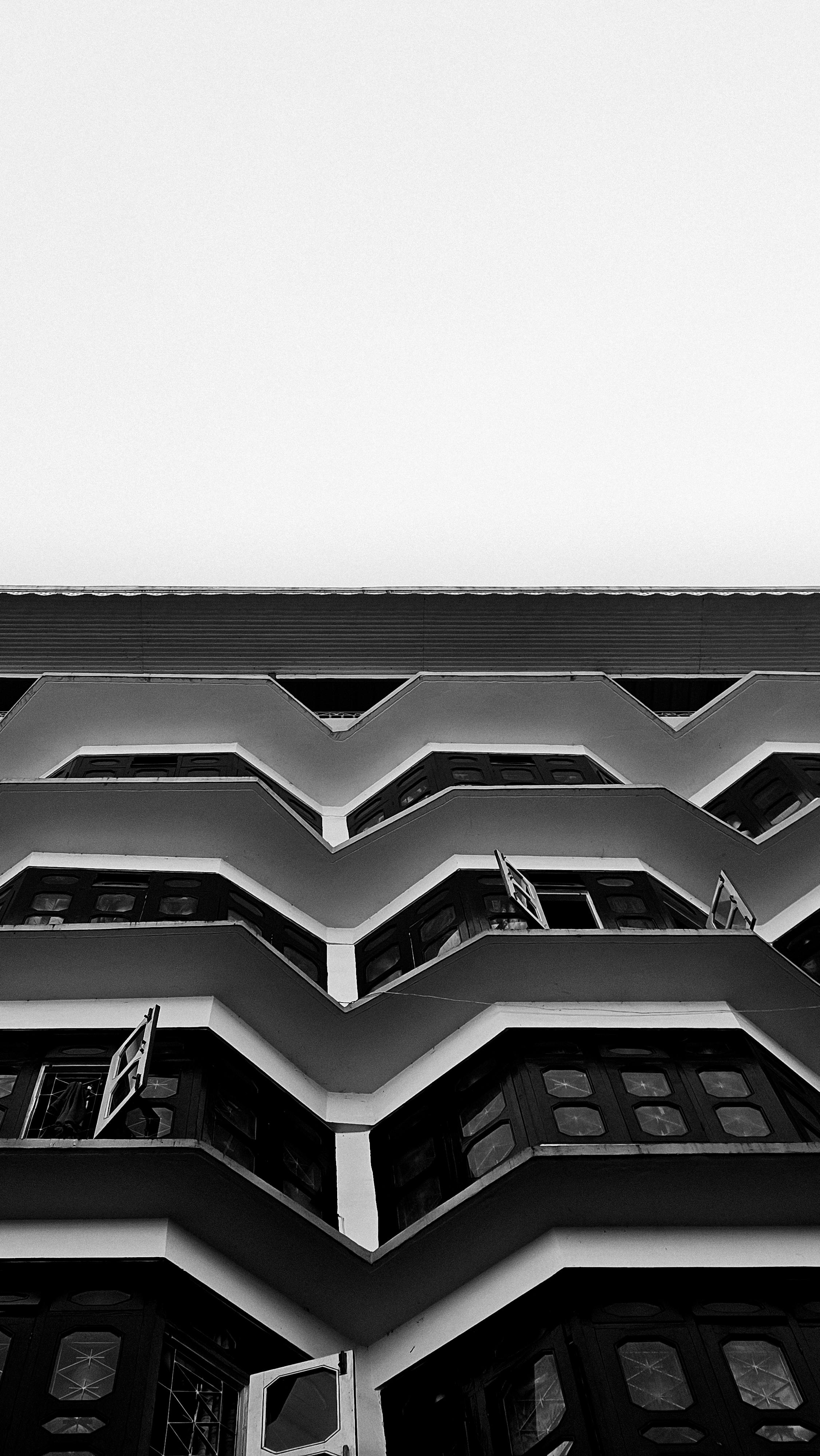 Kostnadsfria Geometrisk svartvit fasad med öppna fönster som skapar en modern abstrakt visuell bild. Stock foto