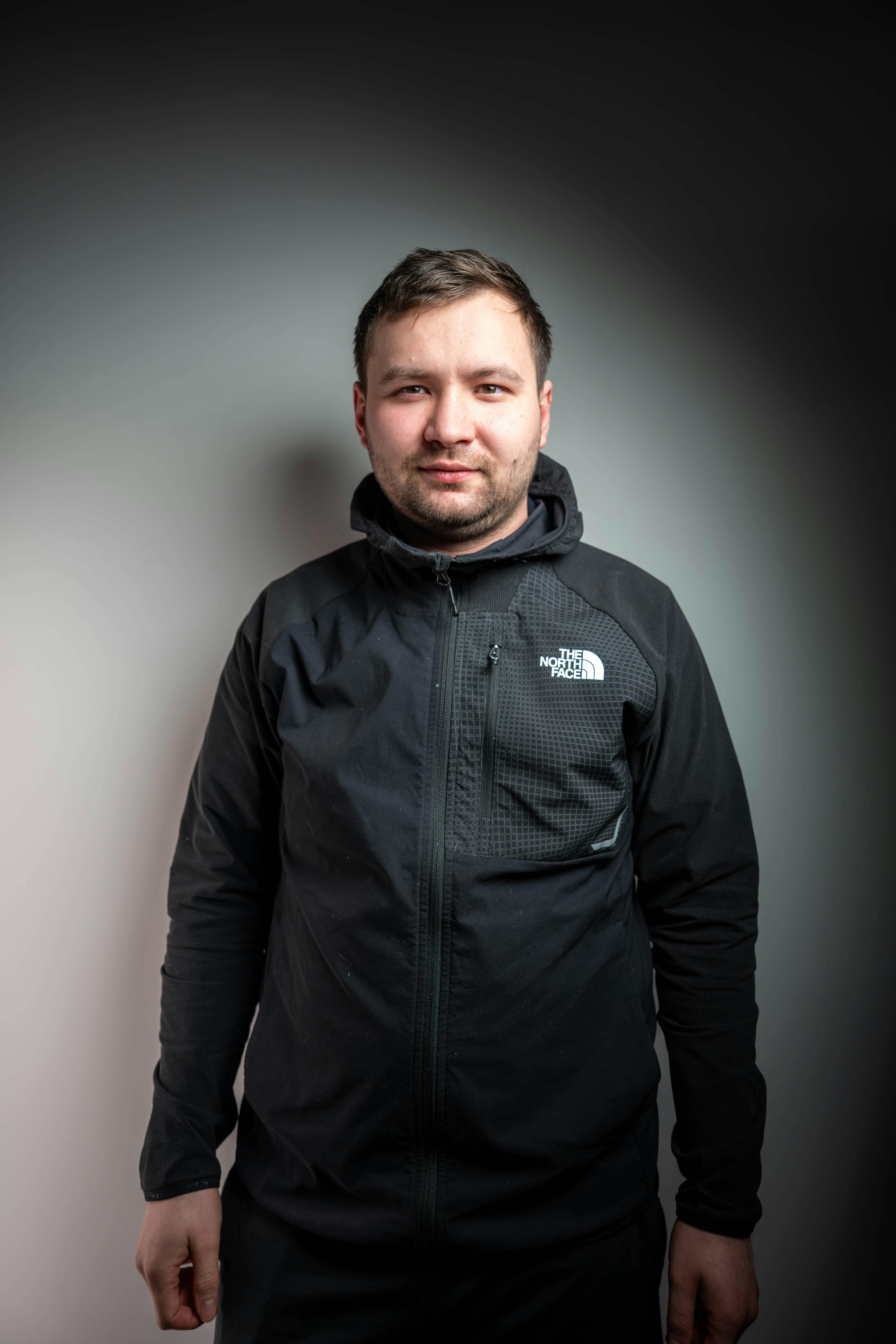 Gratis Retrato de un hombre vestido con una chaqueta negra en un entorno de estudio, mostrando un estilo informal y una expresión neutral. Foto de stock