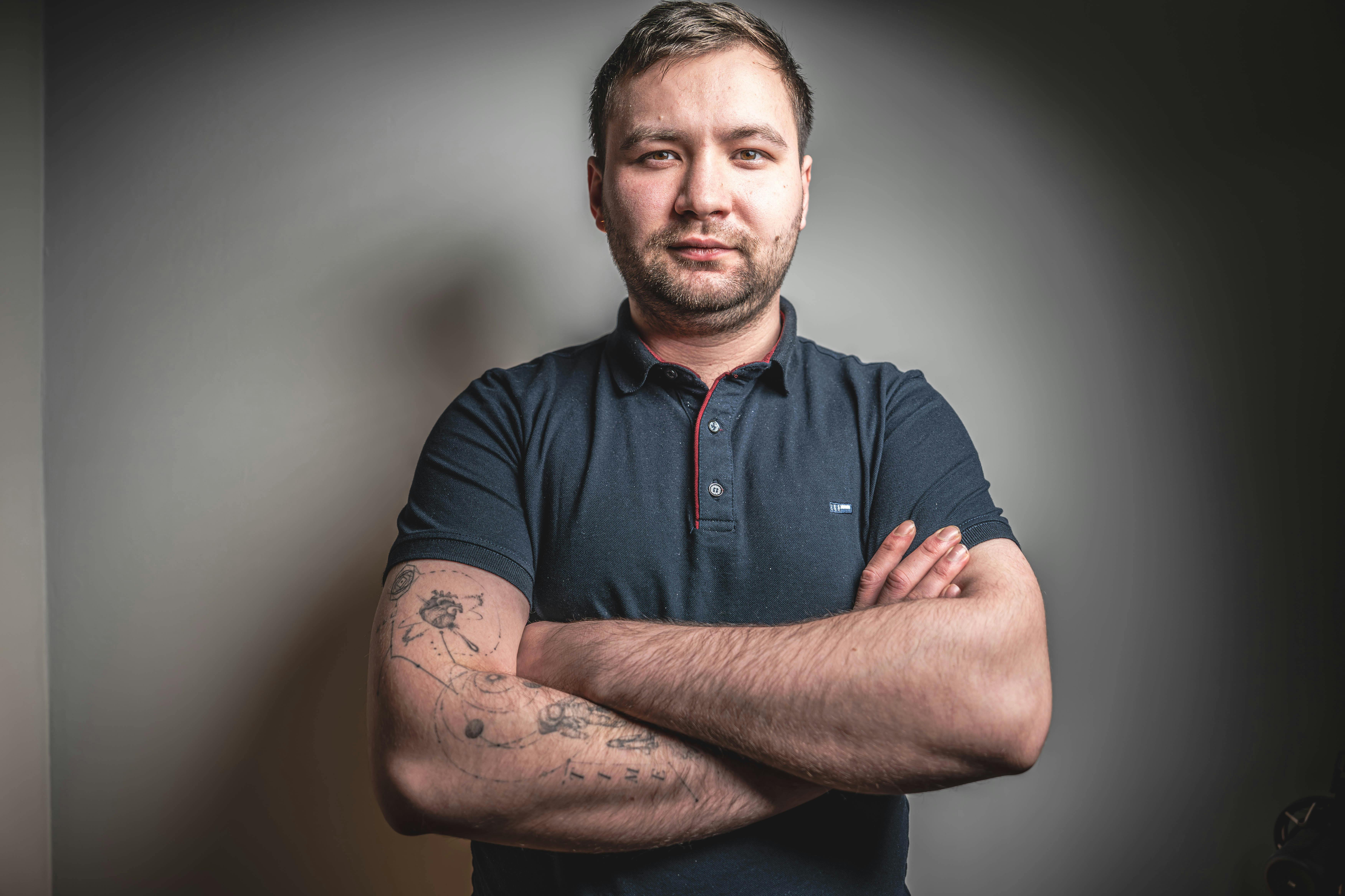 Gratis Retrato de un adulto seguro de sí mismo con tatuajes, brazos cruzados y vestimenta informal. Foto de stock