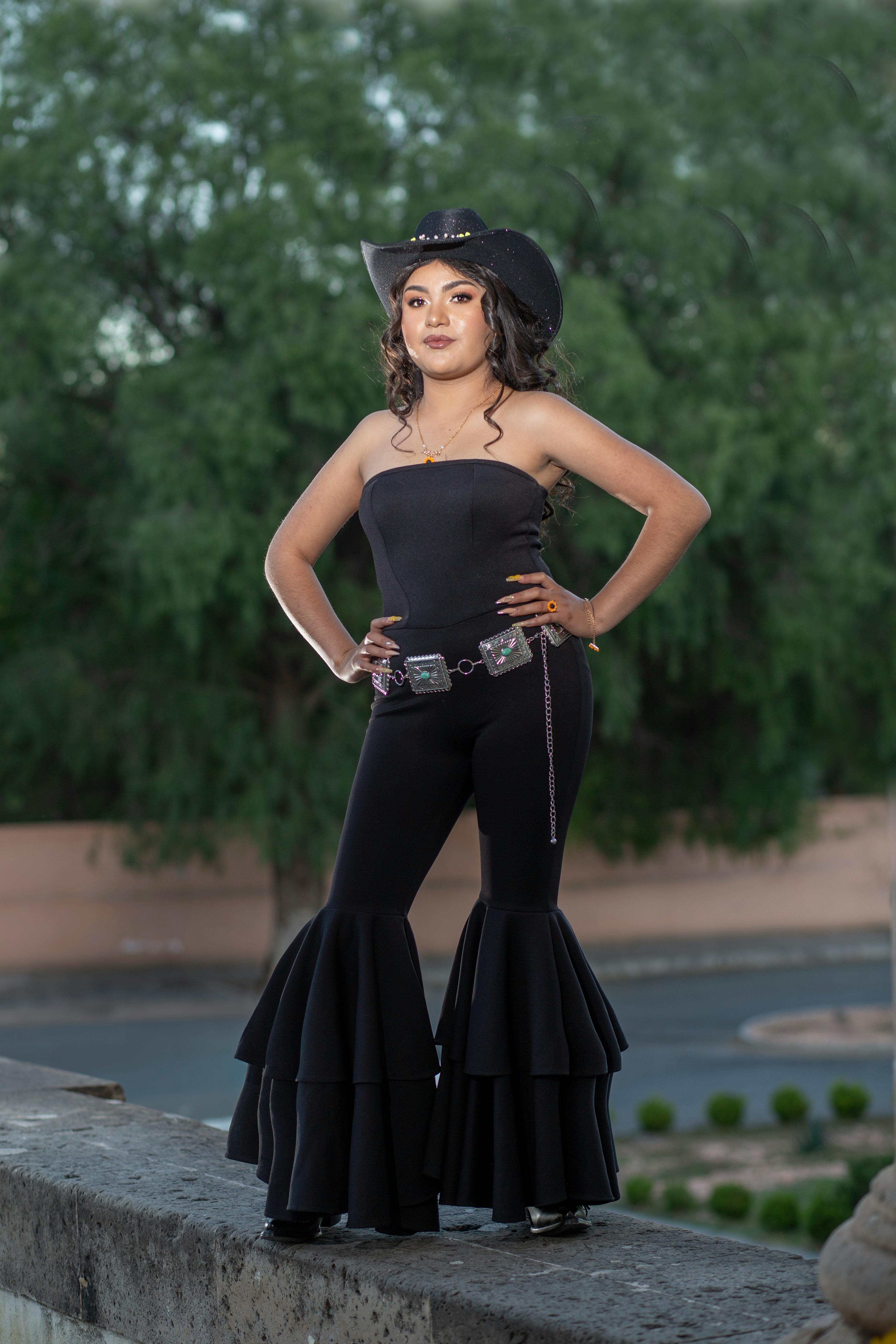 Gratis Mujer segura de sí misma con traje occidental posa al aire libre, con las manos en las caderas, durante el día. Foto de stock